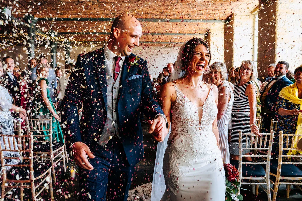 Newlyweds walk through a shower of confetti at The Arches